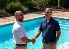 Client shaking hand with contractor by finished pool